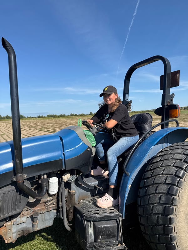 Behind the wheel of a blue tractor in rural Russia