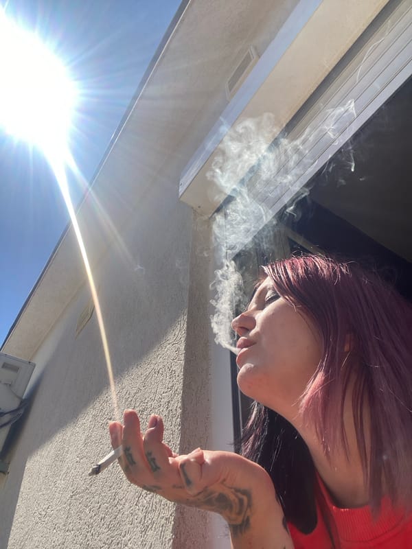 Tattooed woman smoking, drinking coffee observed in Kunje, Montenegro