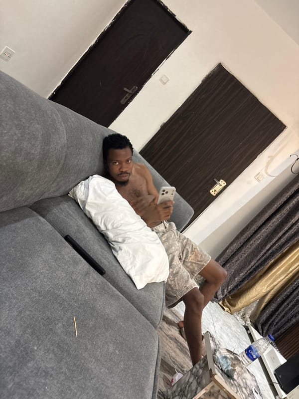 Man relaxes with smartphone in Nigeria living room