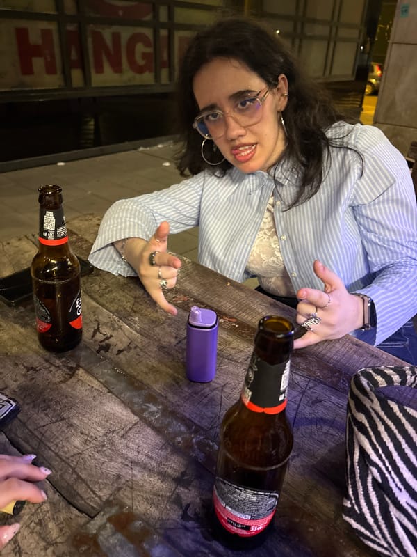 Woman makes rock gesture at Córdoba bar evening scene
