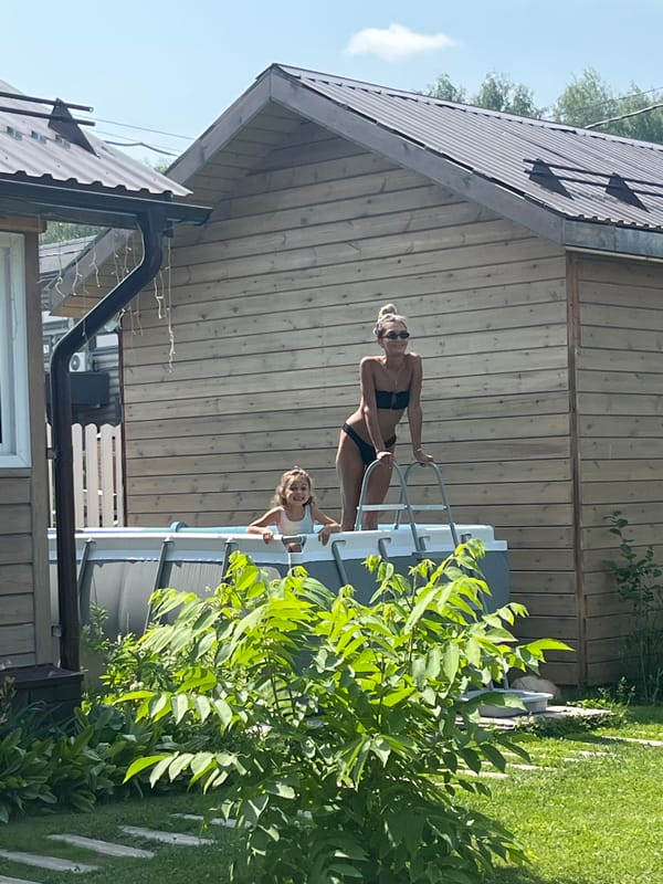 Backyard summer day in Novokamenka: pool, dog, green lawn