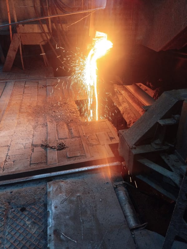 Molten metal pour lights up a dark industrial foundry