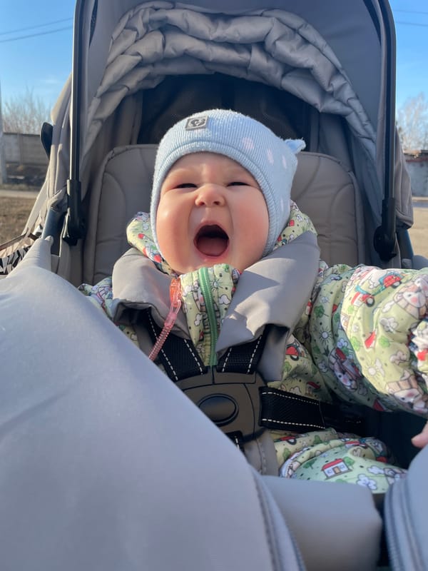 Baby in stroller vocalizes during outdoor outing in Russia