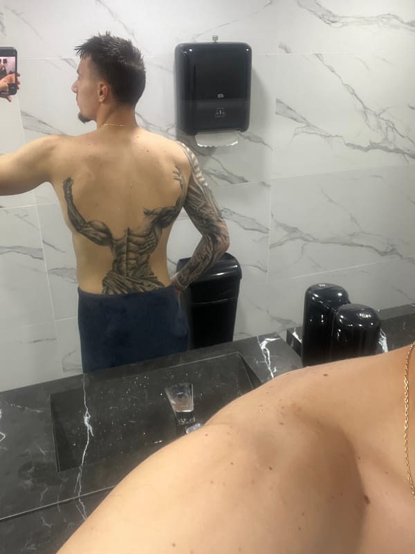 Man with back tattoo photographed in marble bathroom, Petrich