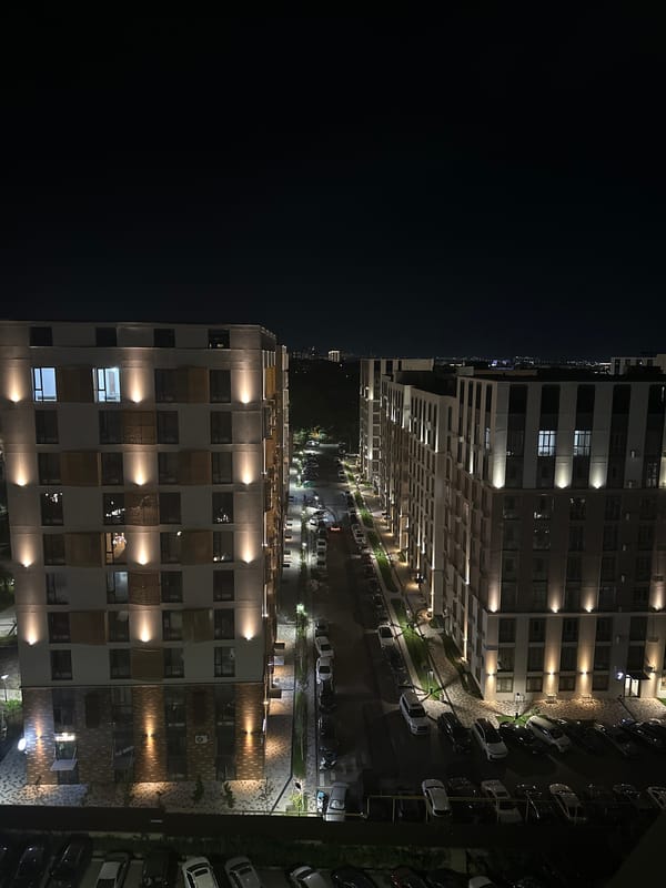 Nighttime street scene outside a modern residential complex