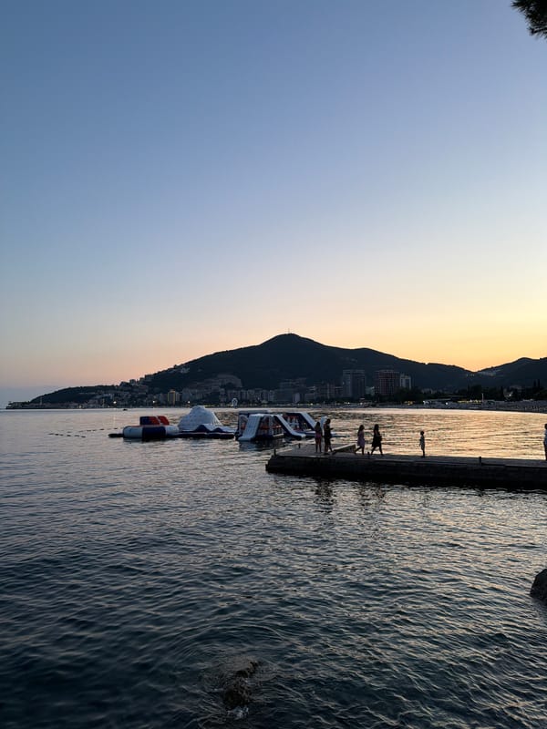 Quiet dusk over Budva's bay, sailboat on still water