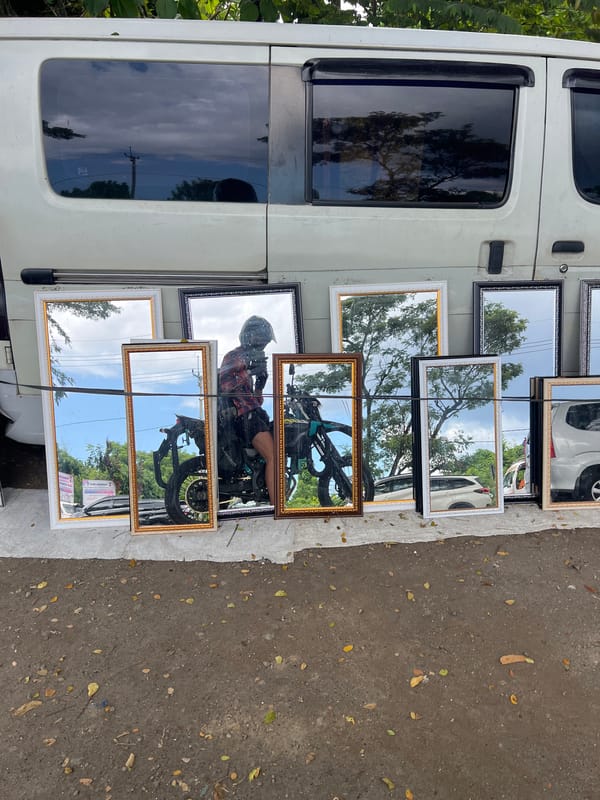 Street vendor displays mirrors, rabbits in cages in Gianyar