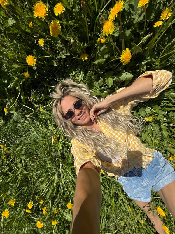 Woman takes selfies in dandelion field near Rusanovo