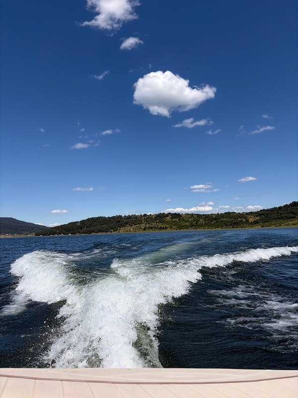 Boating across Batak's deep blue lake waters
