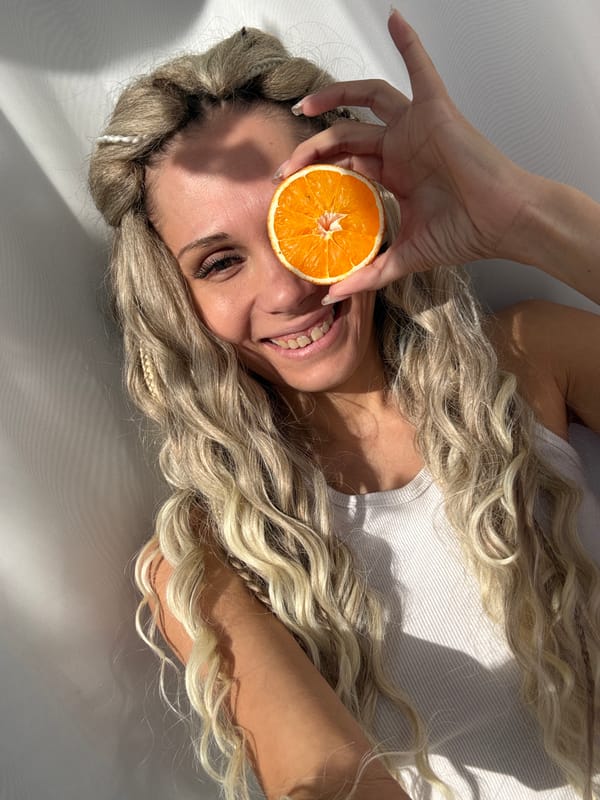 Woman photographed smiling while lying on white surface