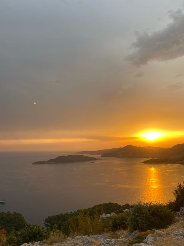 Coastal sunset caught from two angles, water and mountains.