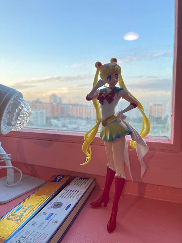 Moscow apartment windowsill with anime figures and city views at dusk