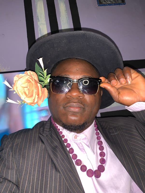 Styled portrait session in Akwanga, Nigeria — fedora, pinstripes, attitude.