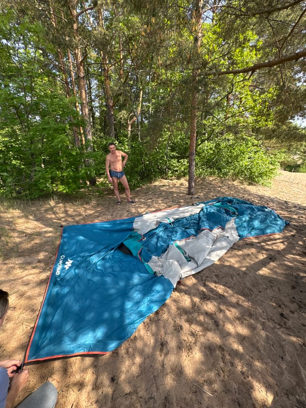 Couple sets up beach camping site in Russian pine forest