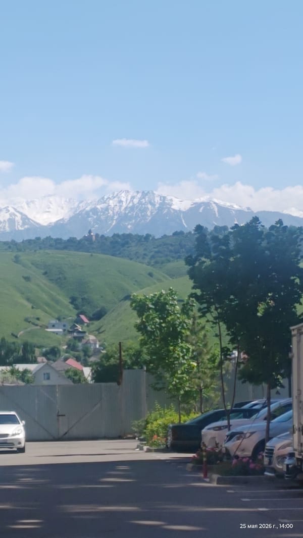 Spring landscape captured in Almaty showing mountains and scattered houses