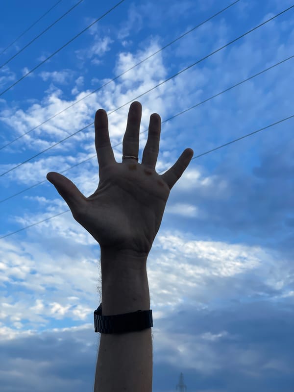 Hand raised to the sky in Aktau, ring and watch visible