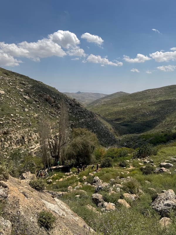 Groups gather on mountainside near Aqraba under spring skies