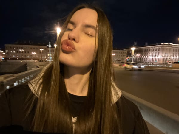Two women walk Saint Petersburg bridge at night
