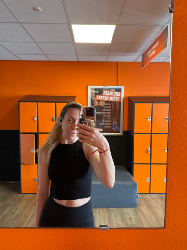 Woman takes mirror selfie in Amsterdam gym locker room
