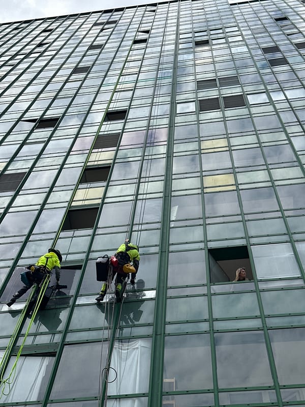 Window washers clean high-rise building facade in Murino, Russia