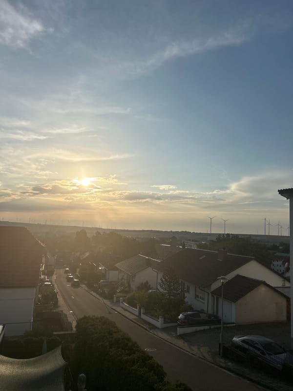 Suburban evening in a European neighborhood with wind turbines and gardens
