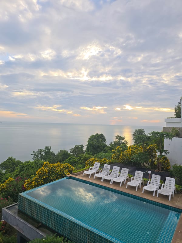 Infinity pool overlooking calm ocean on a cloudy day