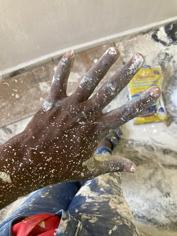 Person paints wall white in Jos, Nigeria