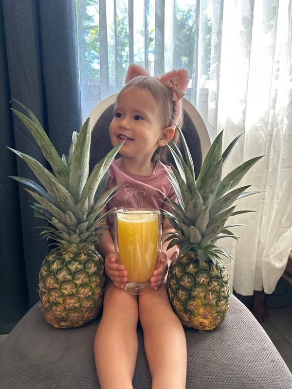 Child with cat ears enjoys pineapples and juice in Wisła home