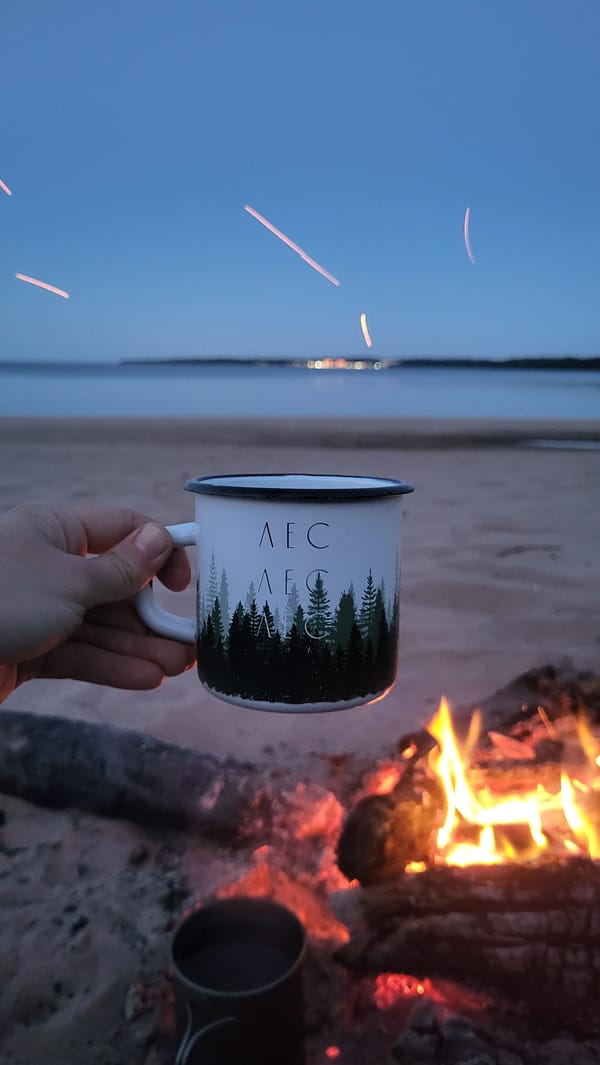 Campfire and forest mugs on a Russian beach at dusk