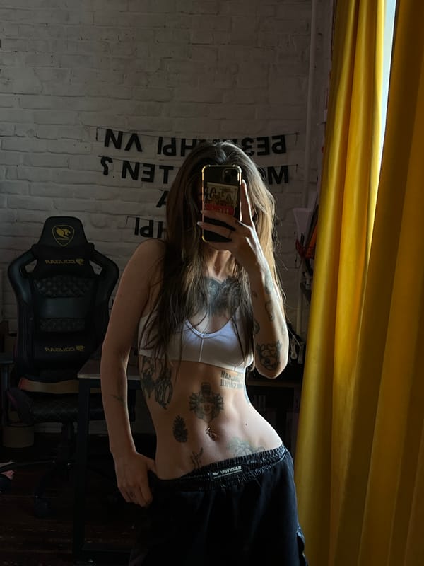 Tattooed individual takes mirror selfie in Krasnoyarsk