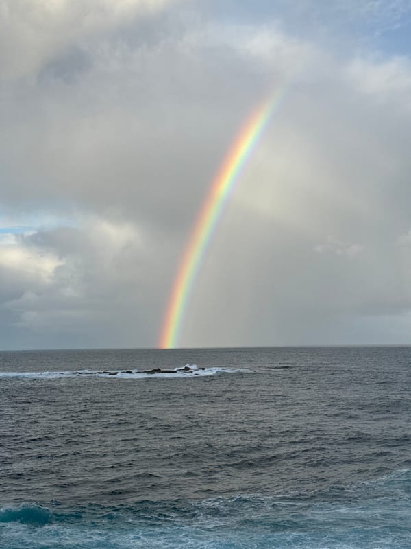 Rainbow over turbulent seas at Clovelly coast