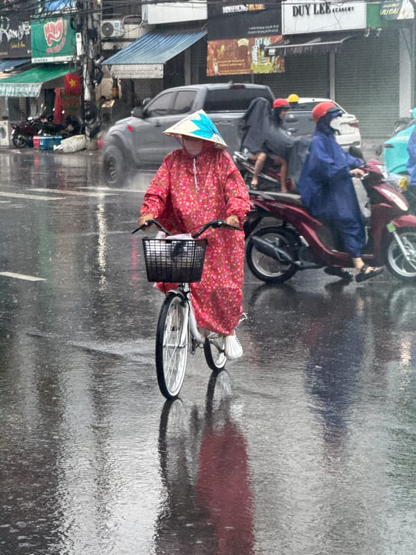 Cyclists navigate rainy streets in Bac Nha Trang Ward