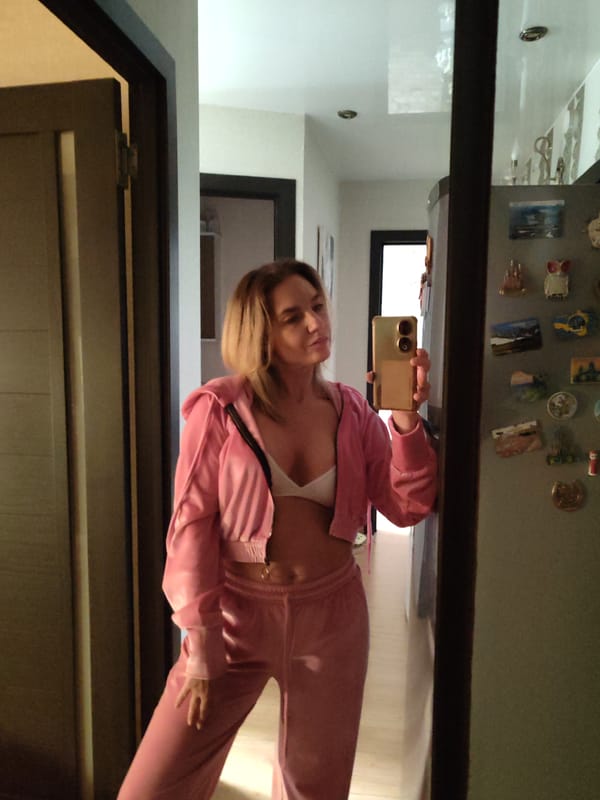 Woman takes mirror selfies in pink tracksuit, Petropavlovsk-Kamchatsky apartment