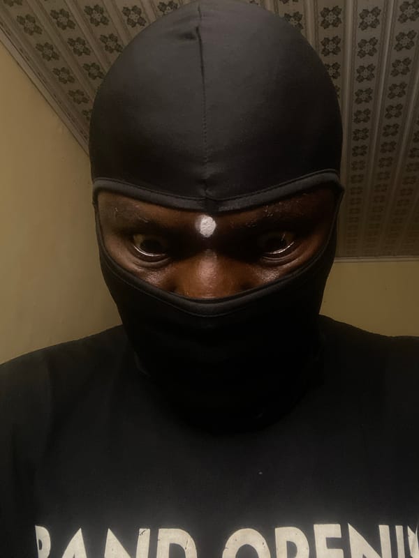 Masked individual photographed multiple times indoors in Jos, Nigeria