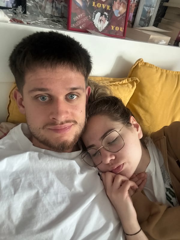 Couple relaxes in bed while watching videos in Bulgaria