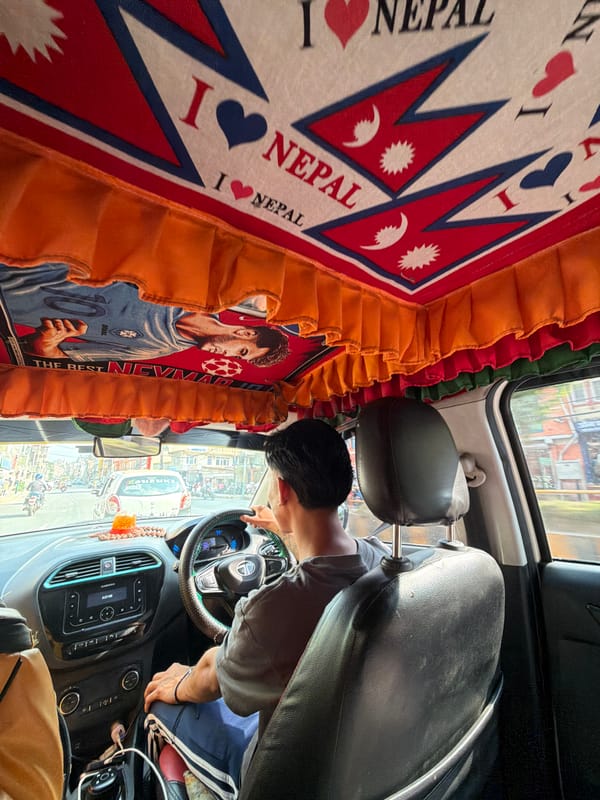 Driver navigates through Kathmandu streets, viewed from back seat