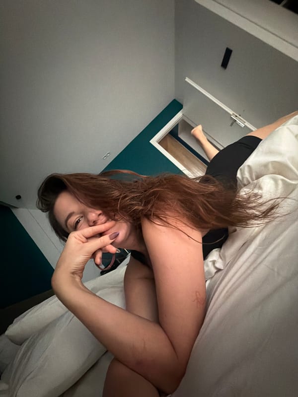 Woman observed smiling, gesturing in Athens bedroom