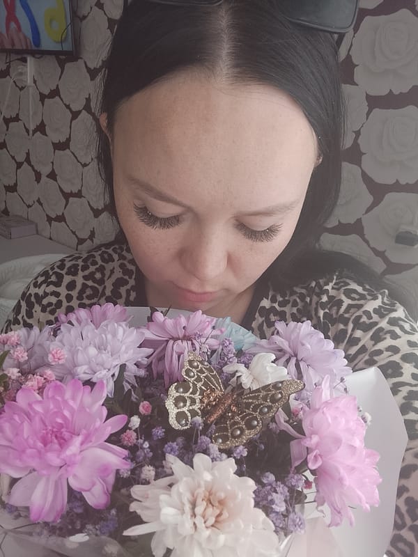 Woman holds flower bouquet in early morning Kuyeda