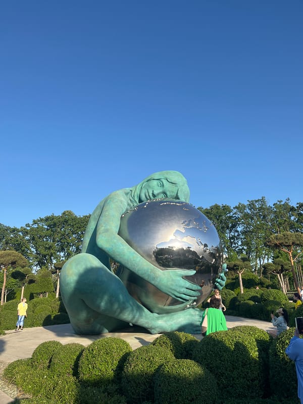 Park visitors observe Girl Holding World sculpture in Krasnodar