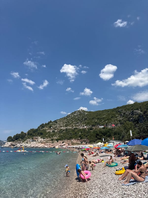 Kamenovo beach in full summer swing — crowd, sea, and sky.