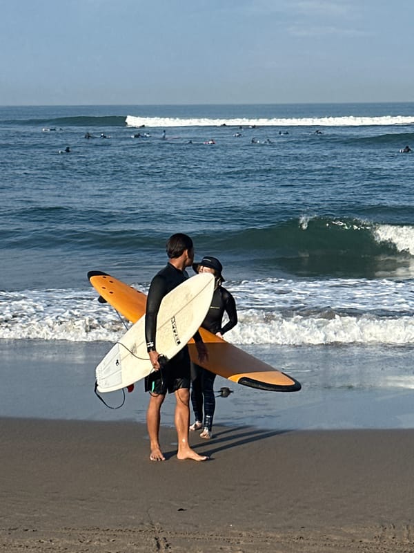 Surfers, beachgoers, and dogs on a North Kuta morning