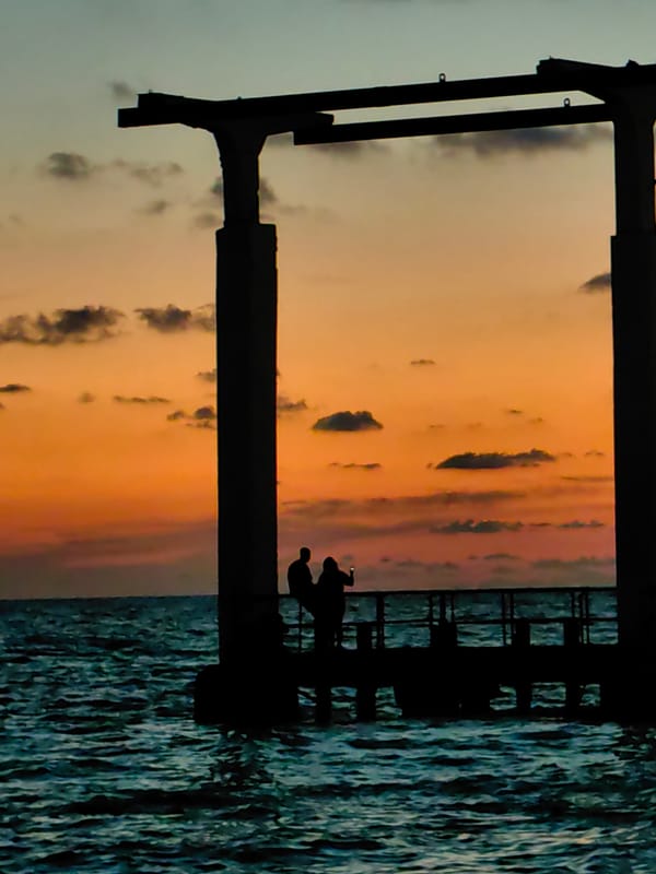 Sunset to twilight along the coast, pier, fountain, and shoreline
