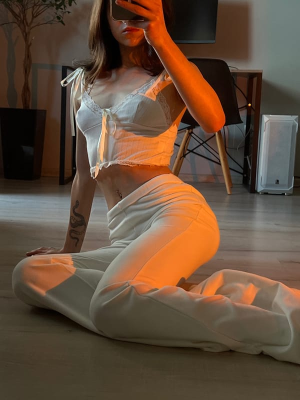 Woman takes mirror selfies in white outfit in Ternopil apartment