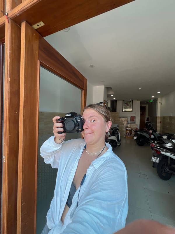 Woman takes mirror selfie with Nikon camera in Vietnam