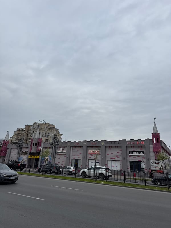 Person in pink hoodie walks past castle-themed building in Plovdiv
