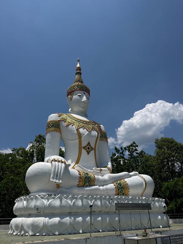 Visitors document ornate Buddha statues at Thailand temple complex