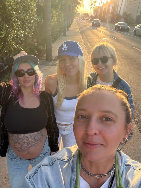 Four women photographed together on Los Angeles street