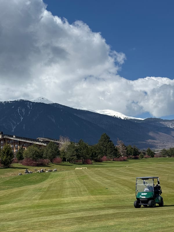 Man rests on Razlog golf course amid mountain scenery