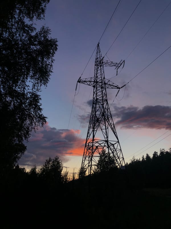 Transmission tower silhouetted against colorful twilight sky in Russia