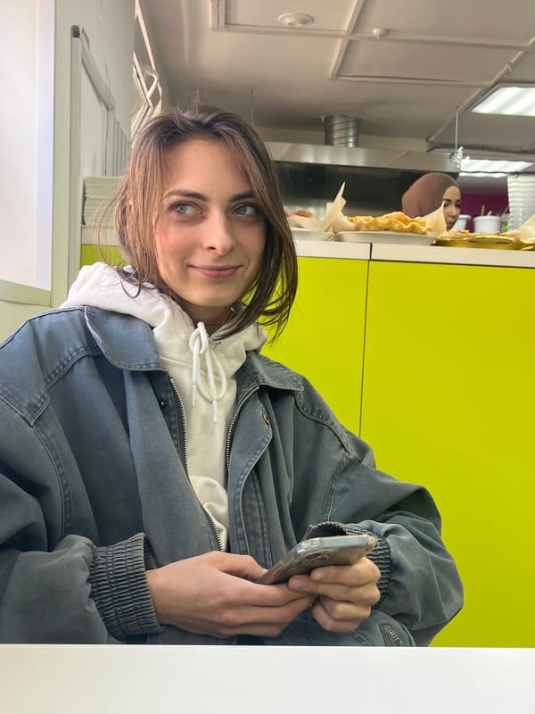 Woman photographed at white table in casual indoor setting